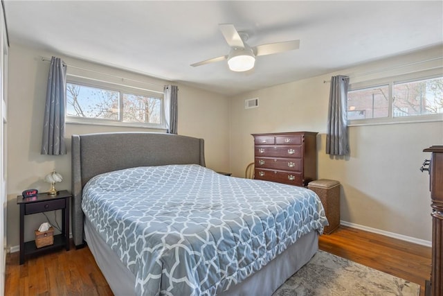 bedroom with ceiling fan, dark hardwood / wood-style floors, and multiple windows