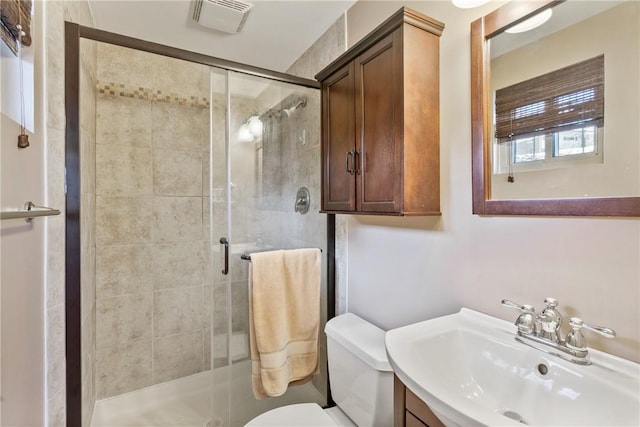 bathroom with vanity, toilet, and a shower with shower door