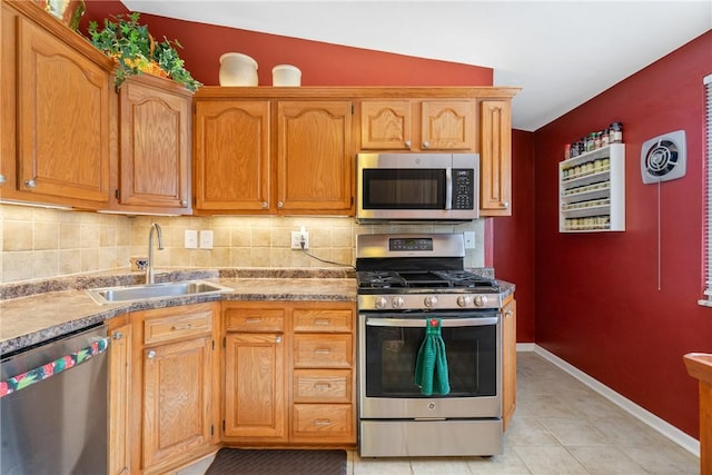 kitchen with sink, vaulted ceiling, decorative backsplash, appliances with stainless steel finishes, and light tile patterned flooring