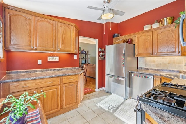 kitchen featuring appliances with stainless steel finishes, backsplash, ceiling fan, sink, and light tile patterned floors