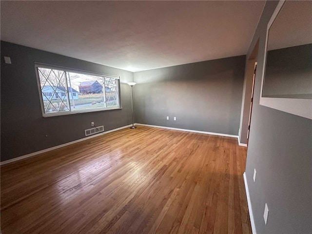 unfurnished room with hardwood / wood-style flooring