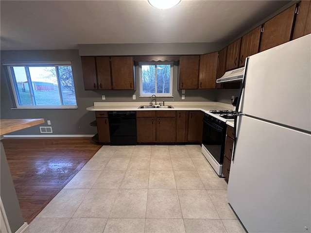 kitchen with a wealth of natural light, sink, extractor fan, and white appliances