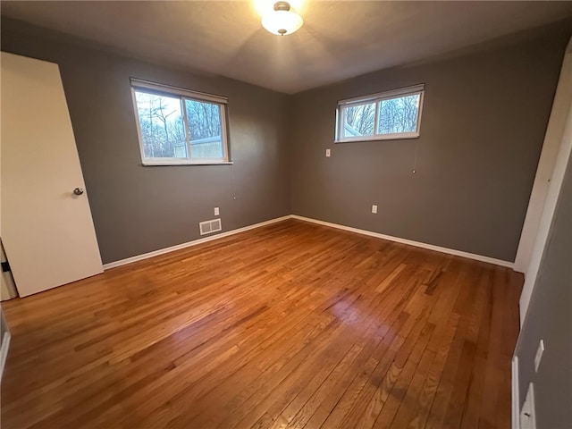 spare room with hardwood / wood-style flooring and a wealth of natural light