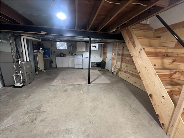 basement featuring independent washer and dryer, sink, and heating unit