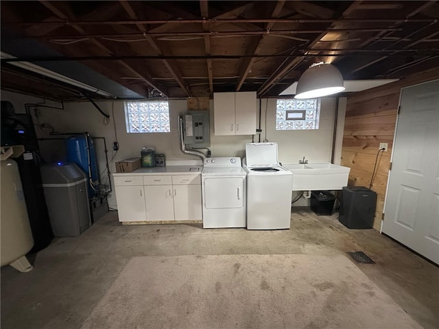 washroom with cabinets, sink, washer and dryer, electric panel, and wood walls