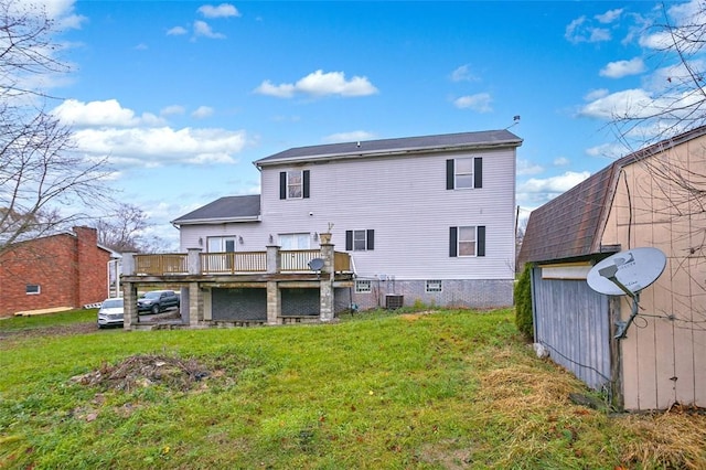 back of property with a lawn, a wooden deck, and an outdoor structure