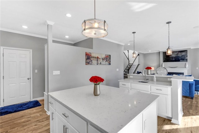 kitchen featuring sink, white cabinets, light hardwood / wood-style floors, and a kitchen island