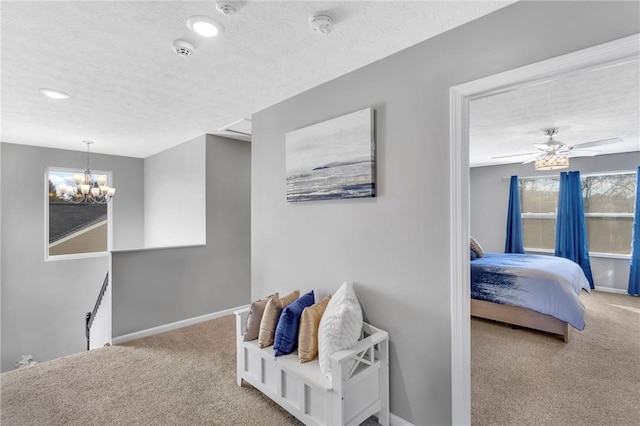 bedroom featuring a textured ceiling, light carpet, and ceiling fan with notable chandelier