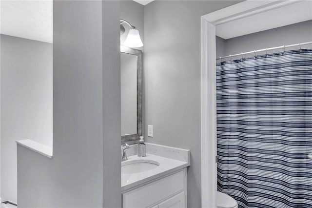 bathroom featuring walk in shower, vanity, and toilet