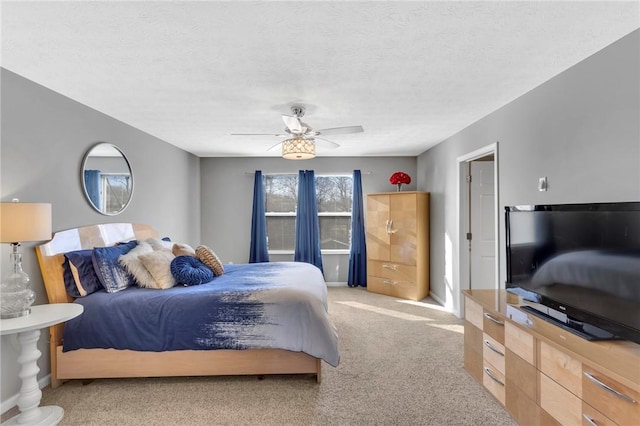 carpeted bedroom featuring ceiling fan and a textured ceiling