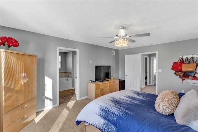 bedroom featuring ceiling fan, light colored carpet, and ensuite bathroom