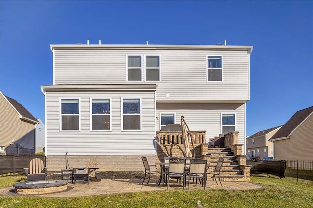 rear view of property with a yard, a patio, and an outdoor fire pit