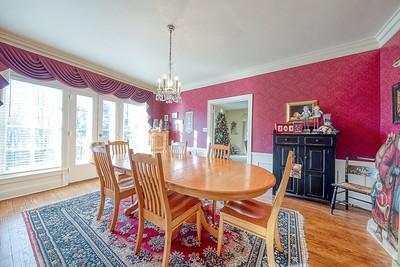 dining space with hardwood / wood-style flooring, crown molding, and a notable chandelier