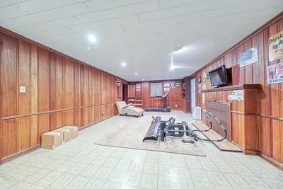 exercise area with wood walls and crown molding