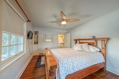 bedroom with dark hardwood / wood-style flooring and ceiling fan