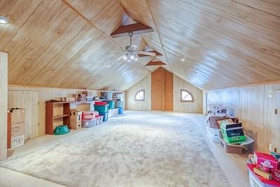 bonus room featuring wood walls, ceiling fan, and lofted ceiling