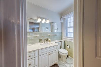 bathroom with vanity, toilet, and tile walls