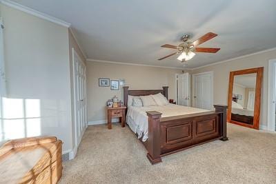 carpeted bedroom featuring ceiling fan and crown molding