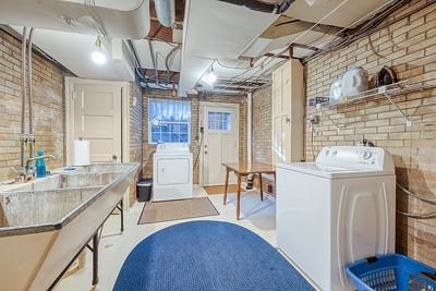 laundry room with brick wall and washer / dryer