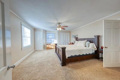 bedroom with light colored carpet, ceiling fan, and lofted ceiling