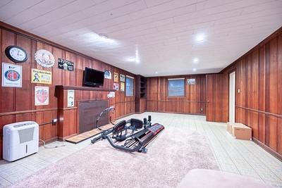 workout area with light carpet, a bowling alley, and wooden walls