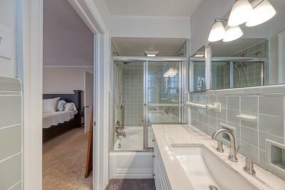 bathroom with vanity, tile walls, and bath / shower combo with glass door