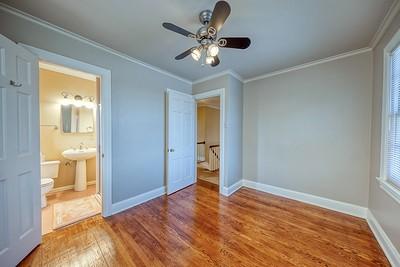 unfurnished bedroom featuring connected bathroom, ceiling fan, sink, hardwood / wood-style flooring, and ornamental molding