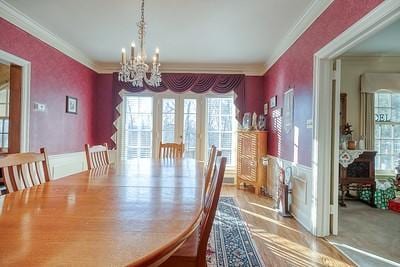 dining area featuring crown molding and an inviting chandelier