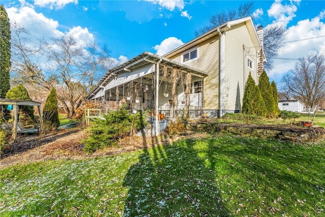 303 Water St, Jamestown, PA 16134 - back of house featuring a sunroom, a chimney, and a lawn