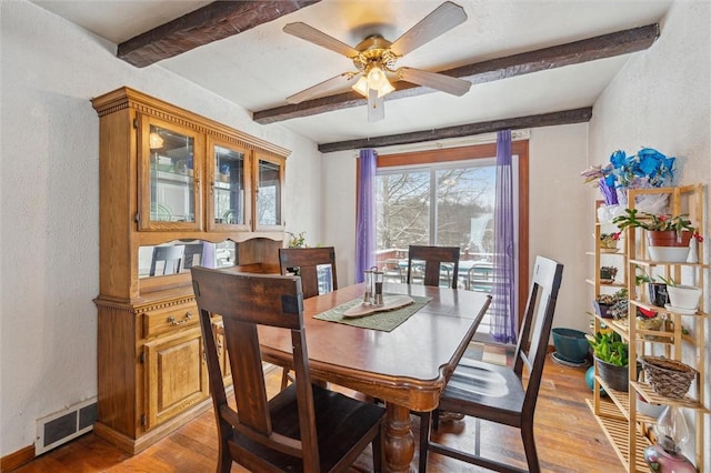 dining area with ceiling fan, light hardwood / wood-style flooring, and beamed ceiling