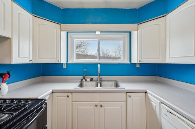 kitchen featuring dishwasher, sink, white cabinets, and black stove