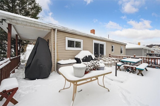 snow covered property with a deck