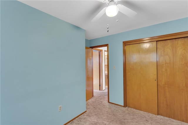 unfurnished bedroom with a closet, ceiling fan, and light colored carpet