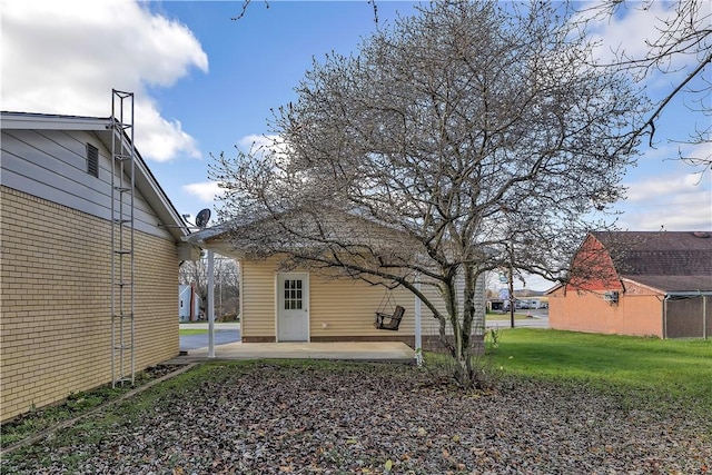 rear view of property featuring a yard and a patio