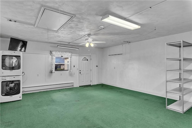 garage with baseboard heating, ceiling fan, and stacked washing maching and dryer