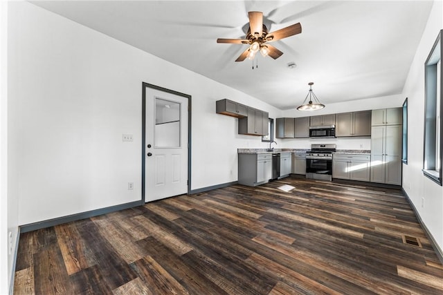 kitchen with appliances with stainless steel finishes, gray cabinets, ceiling fan, and dark wood-type flooring