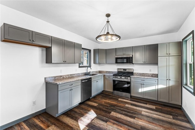 kitchen featuring sink, hanging light fixtures, stainless steel appliances, dark hardwood / wood-style floors, and gray cabinets