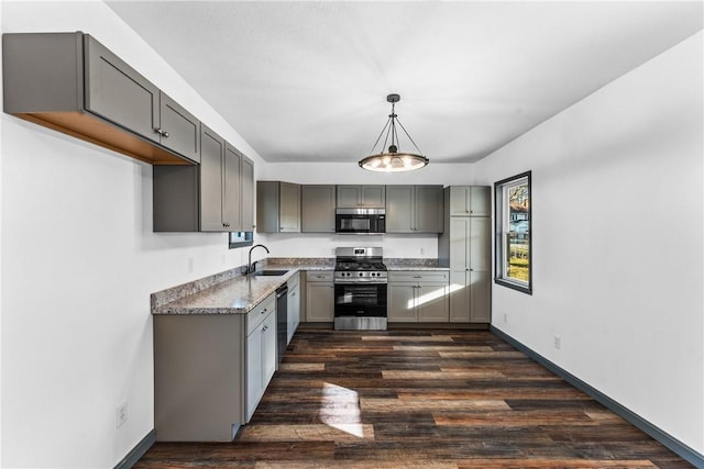 kitchen with sink, stainless steel appliances, dark hardwood / wood-style flooring, decorative light fixtures, and gray cabinets