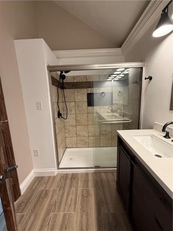 bathroom featuring crown molding, vanity, lofted ceiling, and walk in shower