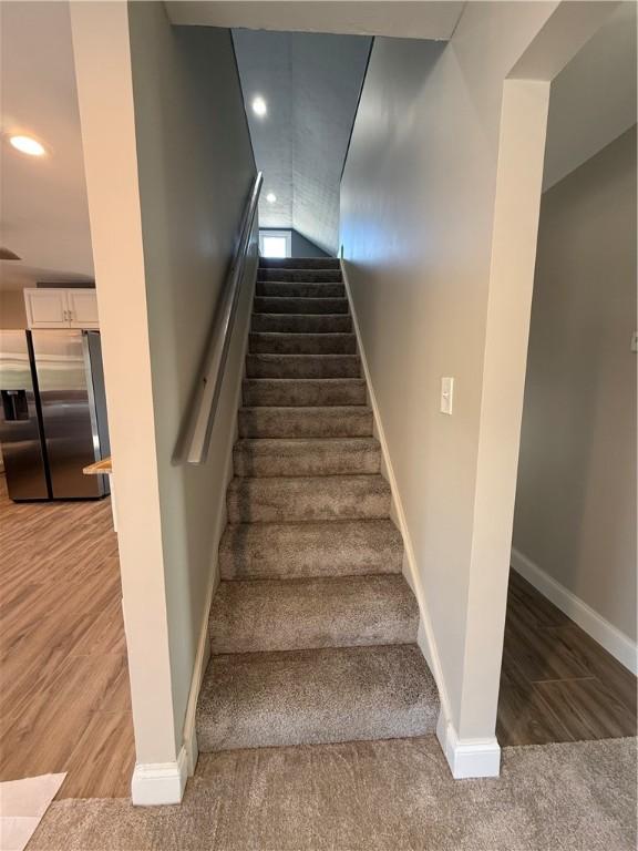 staircase featuring carpet