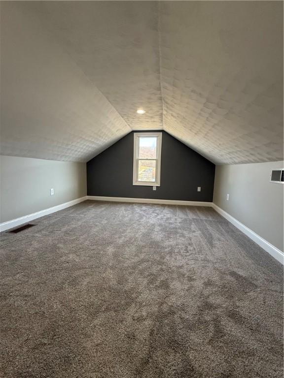 bonus room with carpet and vaulted ceiling