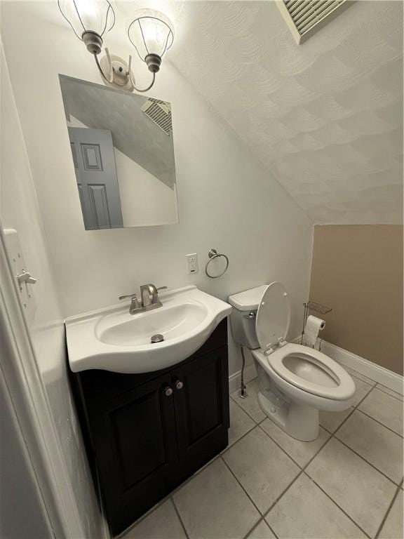 bathroom featuring tile patterned flooring, vanity, lofted ceiling, and toilet