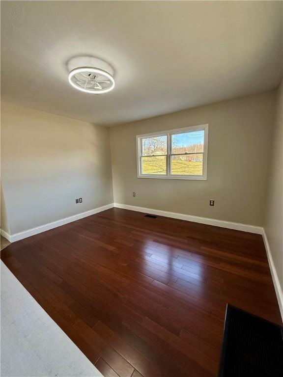 spare room with dark hardwood / wood-style floors