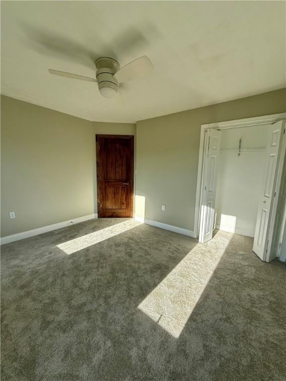 interior space featuring ceiling fan and dark carpet