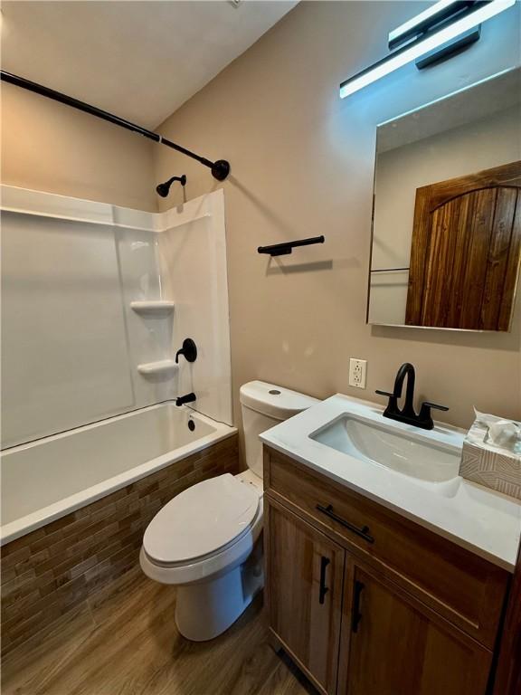 full bathroom featuring vanity, hardwood / wood-style flooring, toilet, and tiled shower / bath