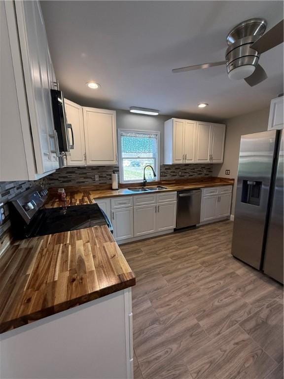 kitchen with backsplash, wooden counters, white cabinets, ceiling fan, and appliances with stainless steel finishes