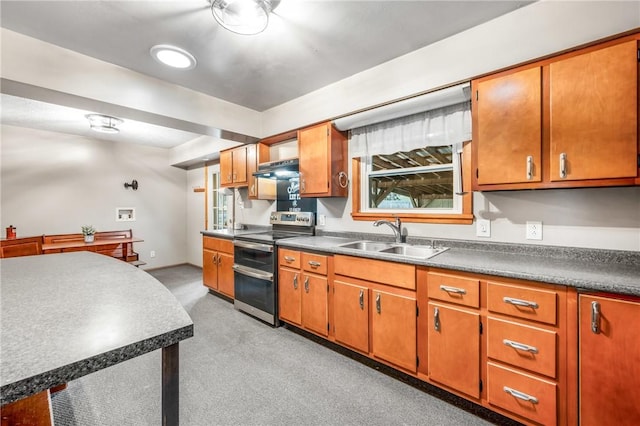 kitchen with stainless steel electric range oven, sink, and light carpet