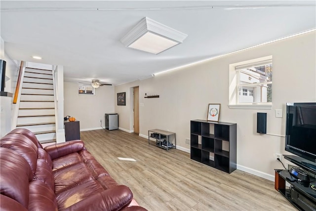 living room with ceiling fan and light hardwood / wood-style flooring