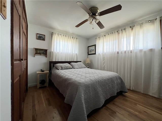 bedroom with ceiling fan and dark wood-type flooring