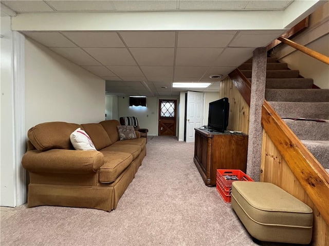 carpeted living room with a drop ceiling